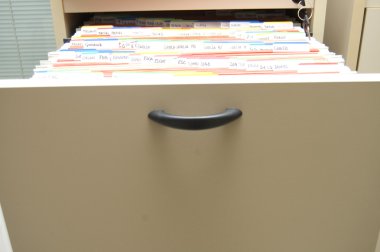 Filing cabinet with folders arranged clipart