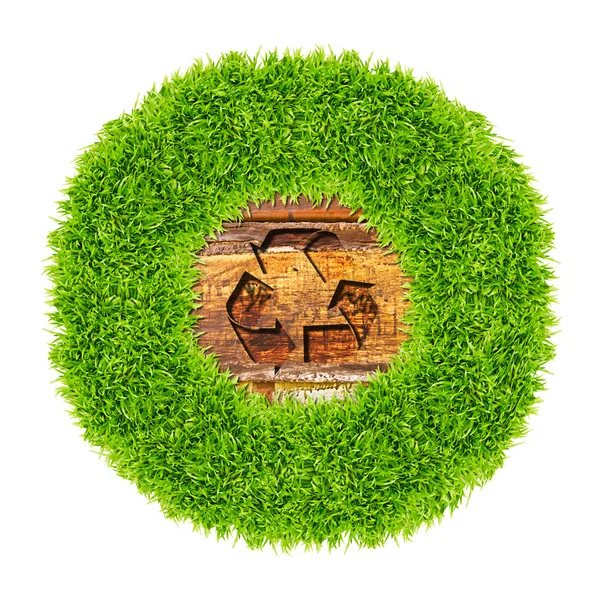 Sinal de reciclagem e grama verde no fundo de madeira — Fotografia de Stock
