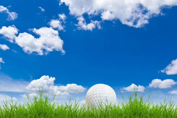 Golf ball on green grass against blue sky — Stock Photo, Image