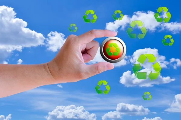 Mão segurando o botão de reciclagem contra o céu azul — Fotografia de Stock