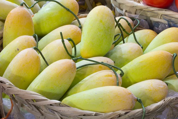 Žluté mango v bambusové koše — Stock fotografie