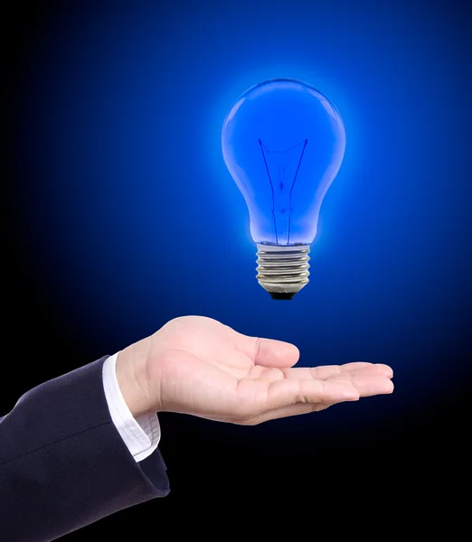 Blue light bulb on hand — Stock Photo, Image