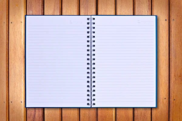 Caderno azul sobre fundo de madeira — Fotografia de Stock