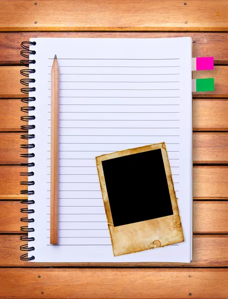 Notebook and vintage photo frame on wood background — Stock Photo, Image