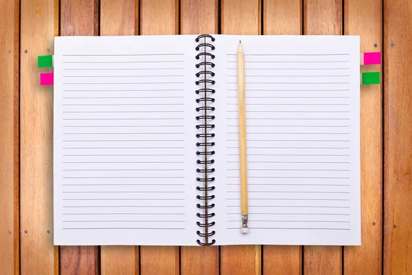 Caderno e lápis sobre fundo de madeira — Fotografia de Stock