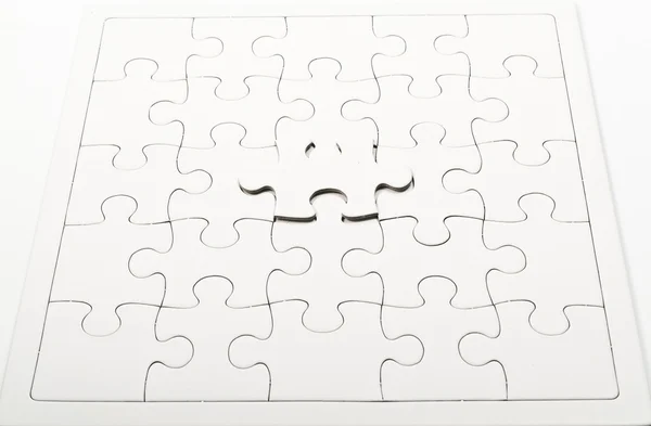 One white jigsaw on jigsaw puzzle pad — Stock Photo, Image