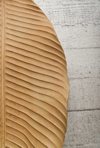 Mezza foglia di banana secca isolata sul pavimento in legno — Foto Stock