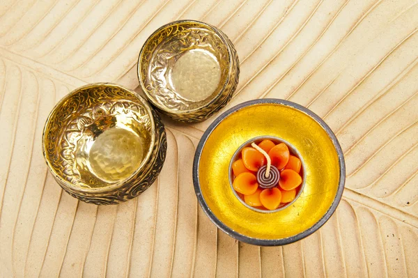 Due ciotole in ottone e ciotola d'oro in legno su foglia di banana marrone — Foto Stock