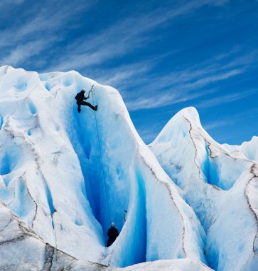 Two men climbing a glacier in patagonia. clipart