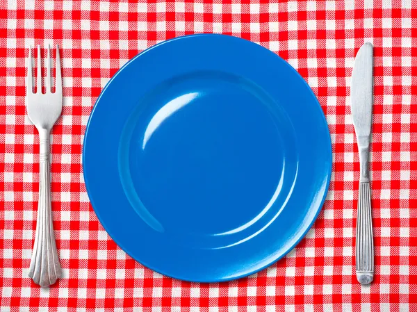 Blue dinner plate with fork and knife — Stock Photo, Image