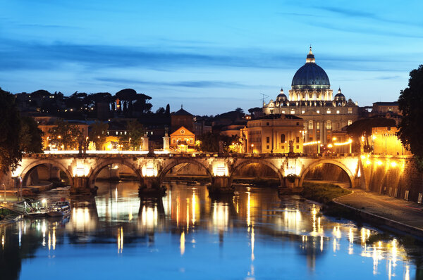Night image of St. Peter's Basilica, Ponte Sant Angelo and Tiber River in Rome - Italy.