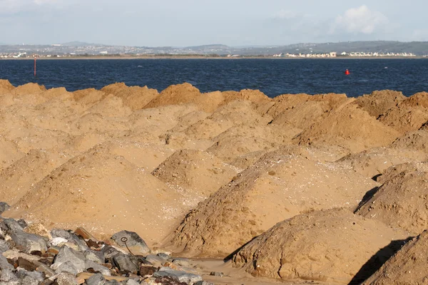 Heuvels van zand op een klein strand — Stockfoto