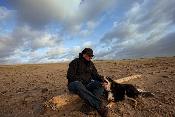 Un homme et son chien dans le désert — Photo