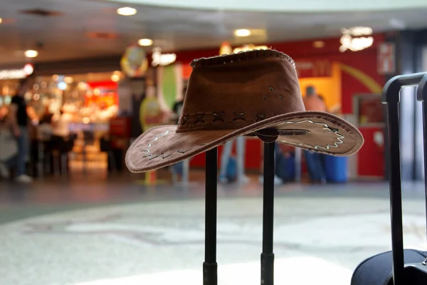 Un chapeau reposant sur une poignée de valise — Photo