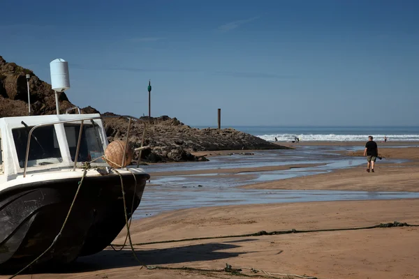 Una barca ancorata sulla sabbia vicino al mare — Foto Stock