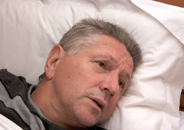 A mature man laying in bed — Stock Photo, Image