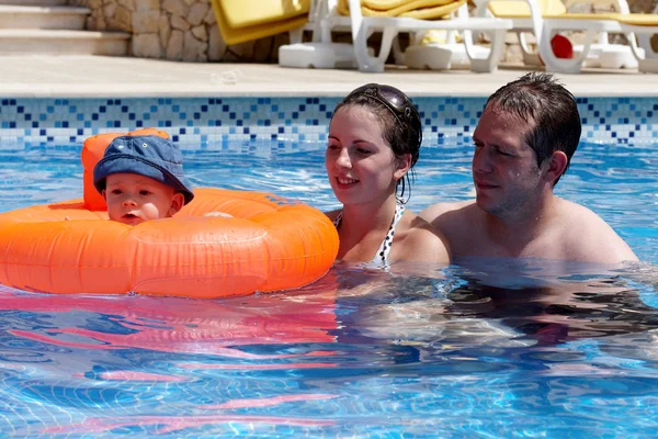 Um jovem casal e bebê em uma piscina — Fotografia de Stock
