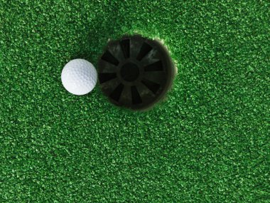 Golf topu deliğin yanında.