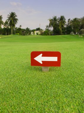 golf kulübünde yeşil çimenlerin üzerinde kırmızı etiket içinde beyaz ok