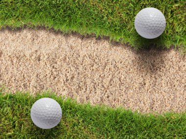 kum BUNKERİ yakınında yeşil çimenlerin üzerinde iki golf topu