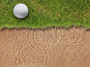 Golf topu su bunke yanında taze yeşil çimenlerin üzerinde