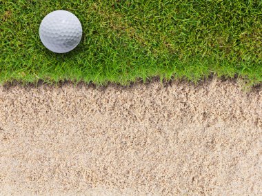 Golf topu kum BUNKERİ yakınında yeşil çimenlerin üzerinde