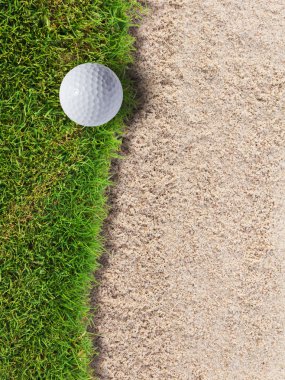 Golf ball on green grass near sand bunker clipart