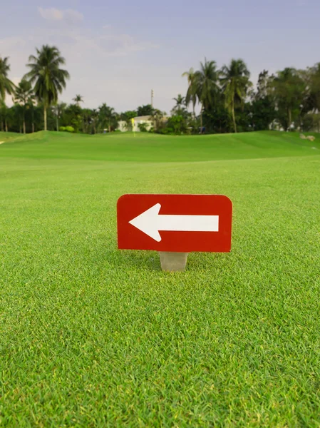 Vita pilen i röd etikett på grönt gräs på golf club — Stockfoto