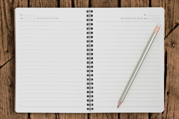 White blank notebook paper and pencil on old wood panel — Stock Photo, Image