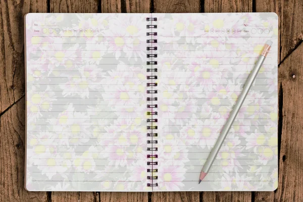 stock image Notebook and beautiful flower on paper and pencil on old wood p