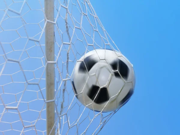 Football spinning in goal against blue sky — Stock Photo, Image