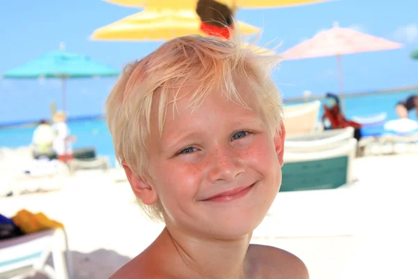 Zeven jaar oude blonde jongen op het strand — Stockfoto