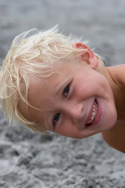 Zes-jarige jongen op strand glimlachen — Stockfoto