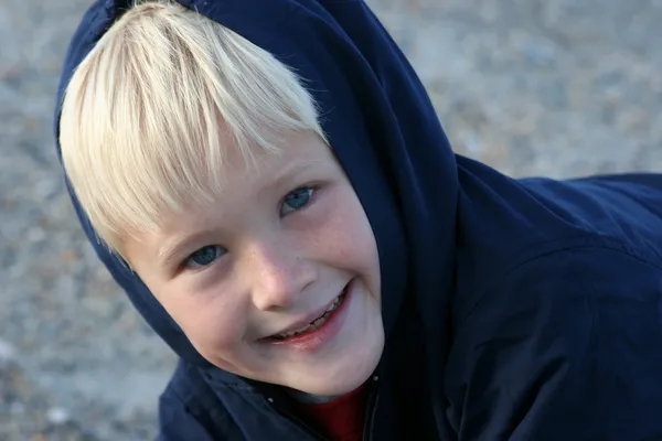 Lachende jongen gebundeld in kleding op het strand — Stockfoto