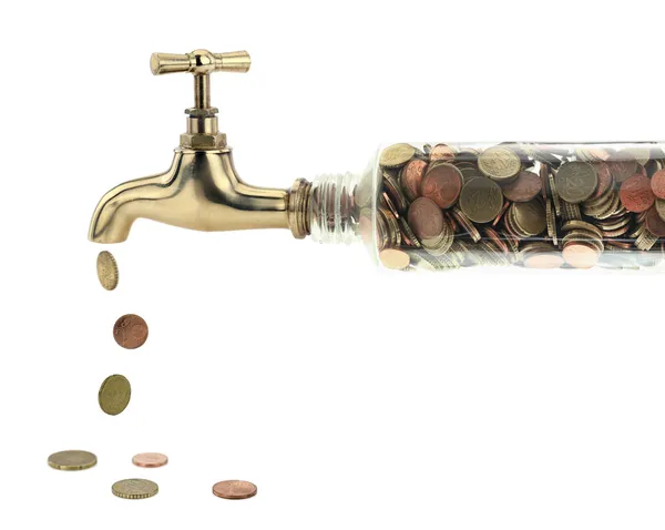 Münzen fallen aus dem goldenen Wasserhahn lizenzfreie Stockfotos