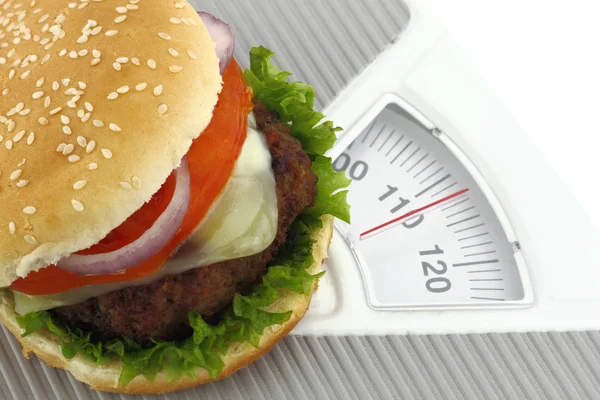 Burger on a weight scale — Stock Photo, Image
