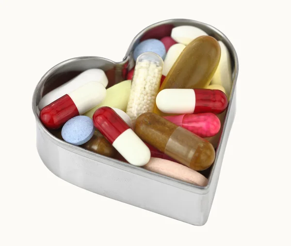 Таблетки в коробке в форме сердца — стоковое фото