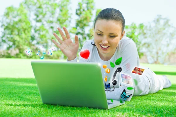 Młoda kobieta piękne rozmowy przez jej laptopa i mobilne bezprzewodowe połączenie z Internetem. — Zdjęcie stockowe