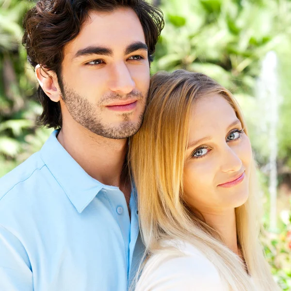 Portrait of love couple embracing outdoor in park looking happy — Stock Photo, Image