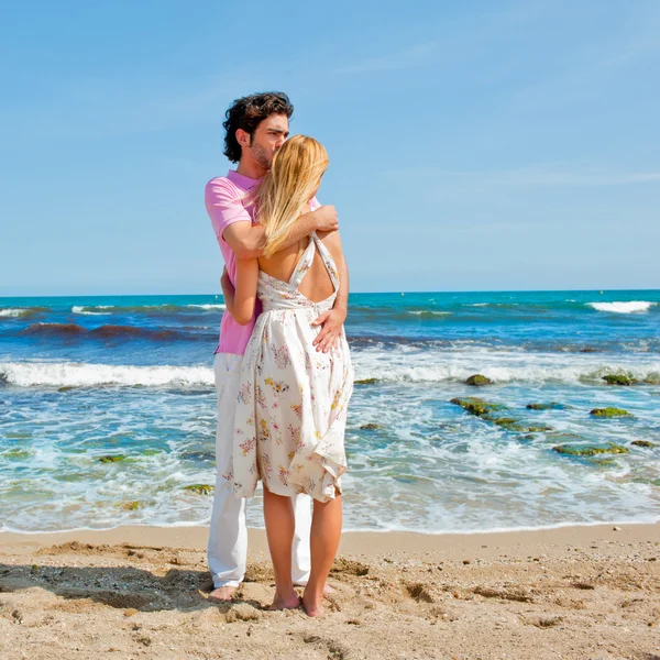 Portret van een jong koppel in liefde omarmen op strand en genieten van — Stockfoto
