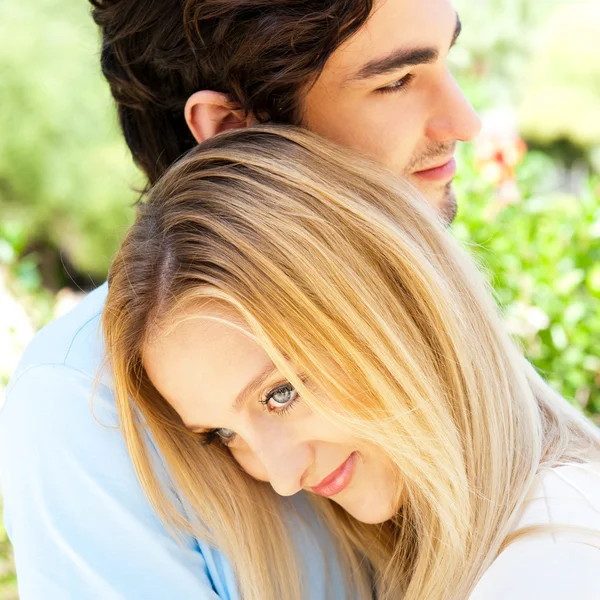 Retrato de casal de amor abraçando ao ar livre no parque olhando feliz — Fotografia de Stock