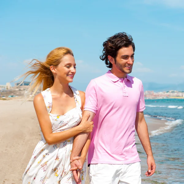 Couple at the beach holding hands and walking. Sunny day, bright Stock Photo
