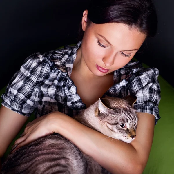 お手玉のソファーでリラックスした猫の幸せな若い女性. — ストック写真