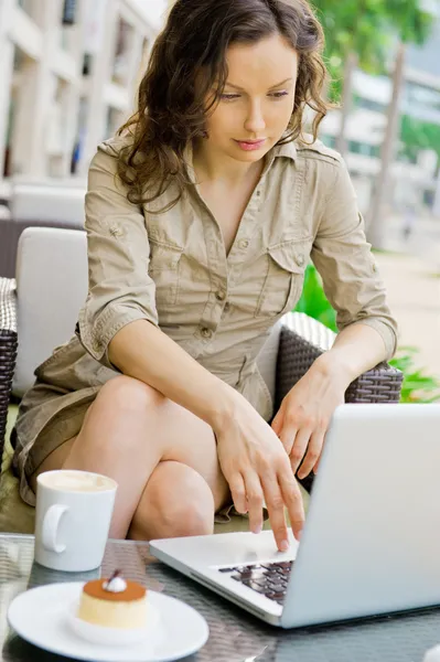 Modern pretty woman having breakfast or lunch at sidewalk cafe and using her laptop and free wifi — Stock Photo, Image