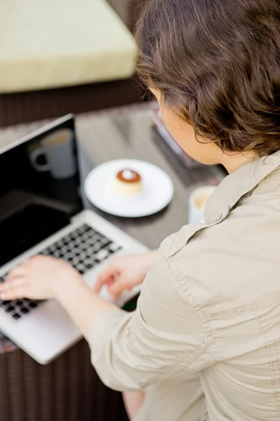 Modern pretty woman having breakfast or lunch at sidewalk cafe and using her laptop and free wifi — Stock Photo, Image