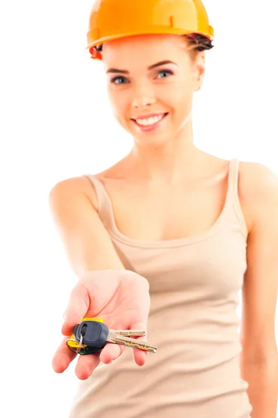 Photo of happy woman construction engineer wearing protective orange helmet holding new key and looking at camera. — Stock Photo, Image