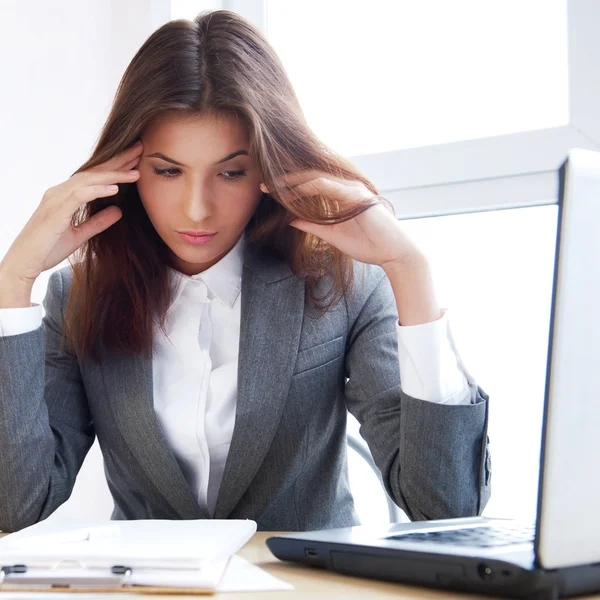 Trött business kvinna som arbetar på hennes arbetsyta — Stockfoto