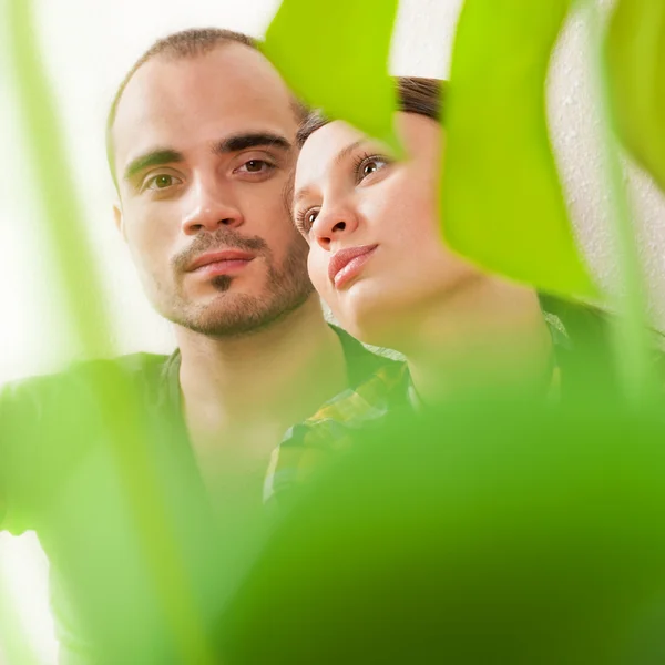 Молодая взрослая пара, сидящая рядом на лиственном полу в — стоковое фото