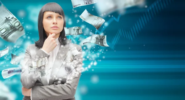 Woman standing with open arms amidst falling money — Stock Photo, Image
