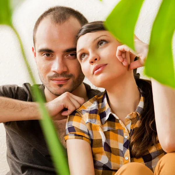 Atraktivní mladý dospělý pár sedící blízko na dřevěnou podlahu v — Stock fotografie